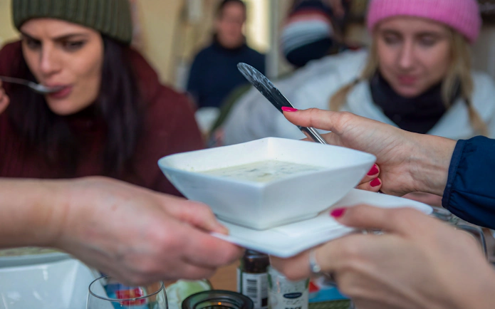 Guests enjoying soup during Tromsø snowmobile tour in Lyngen Alps.