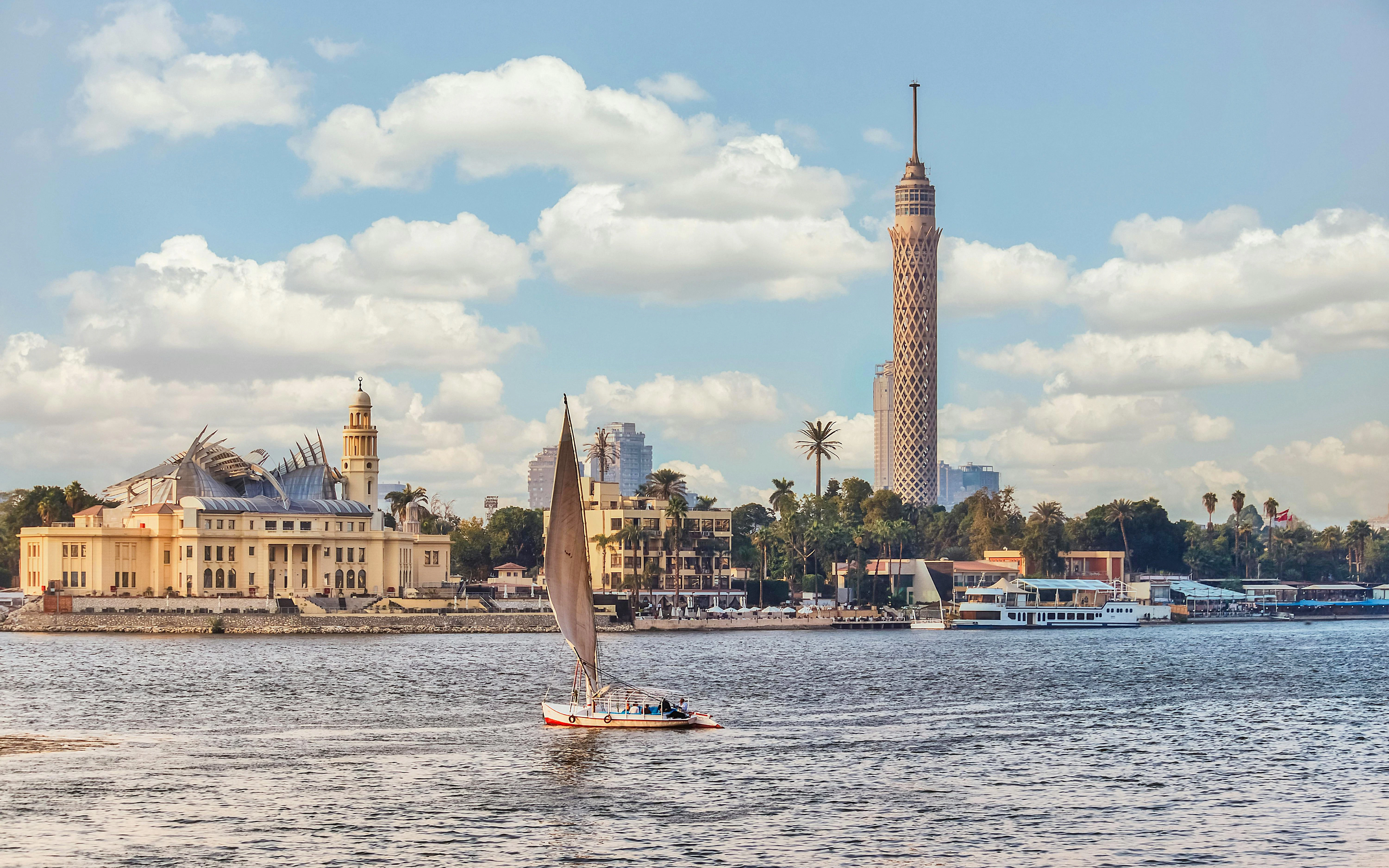 Sailboat on the Nile River with Cairo Tower and cityscape in the background.