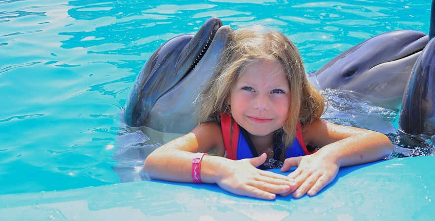 Girl with dolphins at Hurghada Dolphin Show, Egypt Dolphin World.