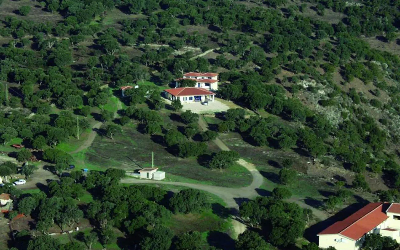 Aerial view of a farmhouse surrounded by greenery in Nuoro for Bitti Shepherd Experience.