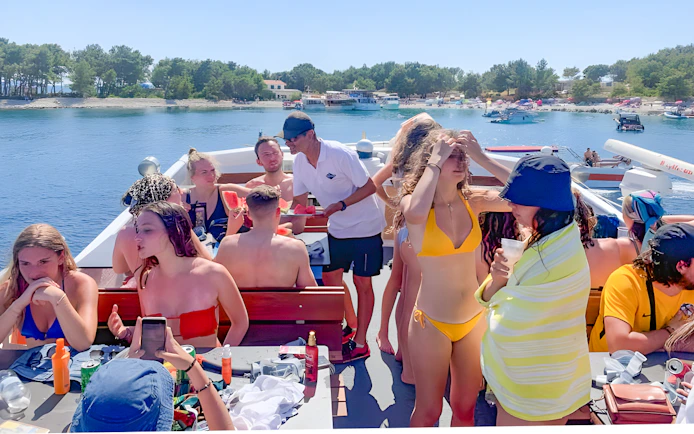 Group enjoying a boat cruise near Split, Croatia, with drinks and watermelon.