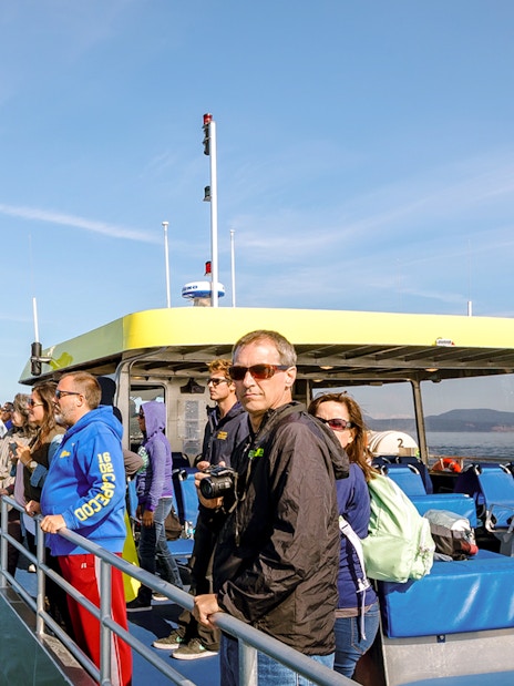 Group on a boat during a whale watching tour in open sea.