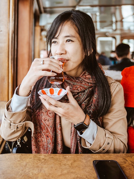 Woman enjoying Turkish tea on a ferry boat.