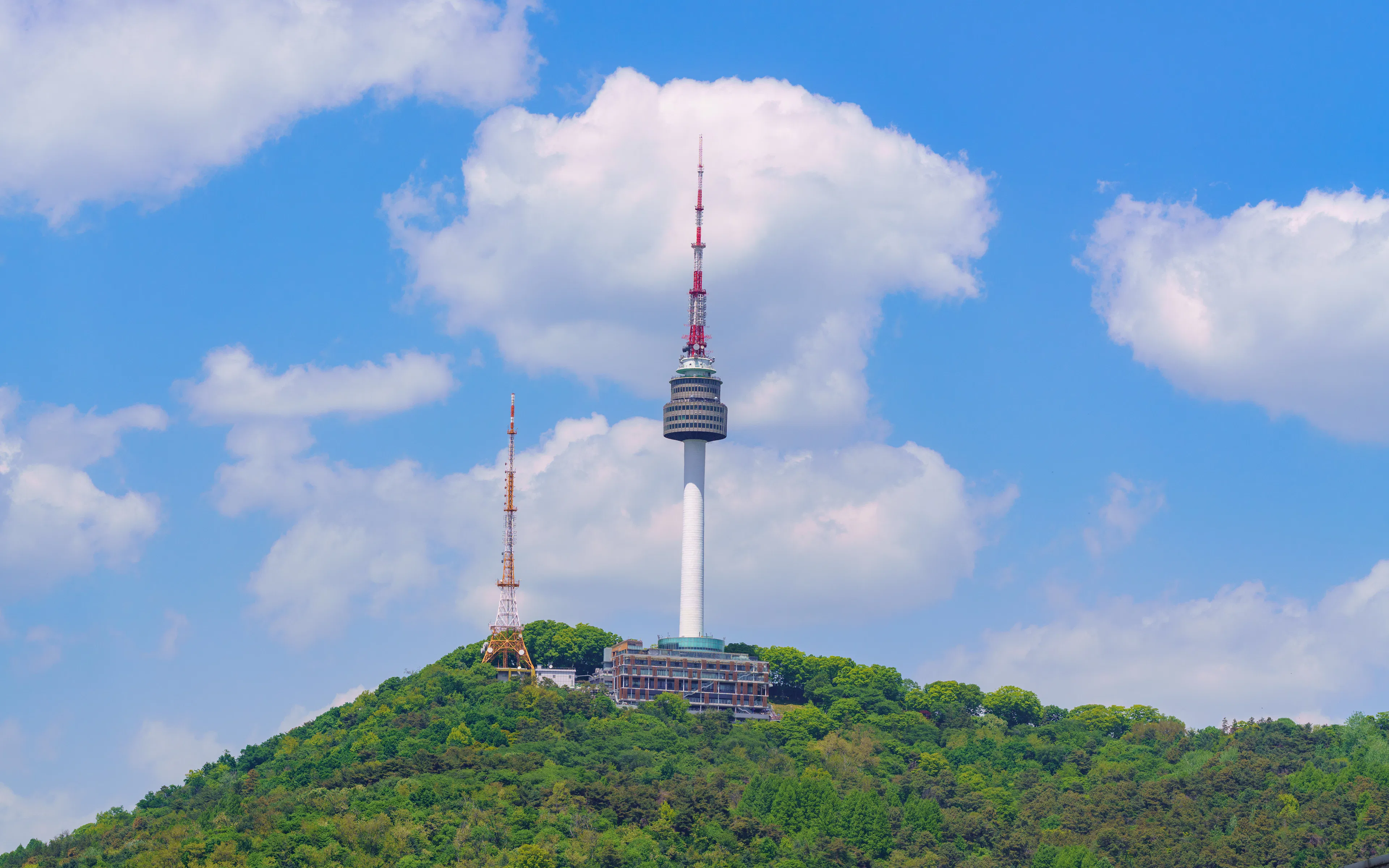 N Seoul Tower on Haebangchon Hillside under a blue sky.