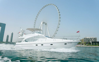 Luxury yacht cruising with Ain Dubai wheel in the background.