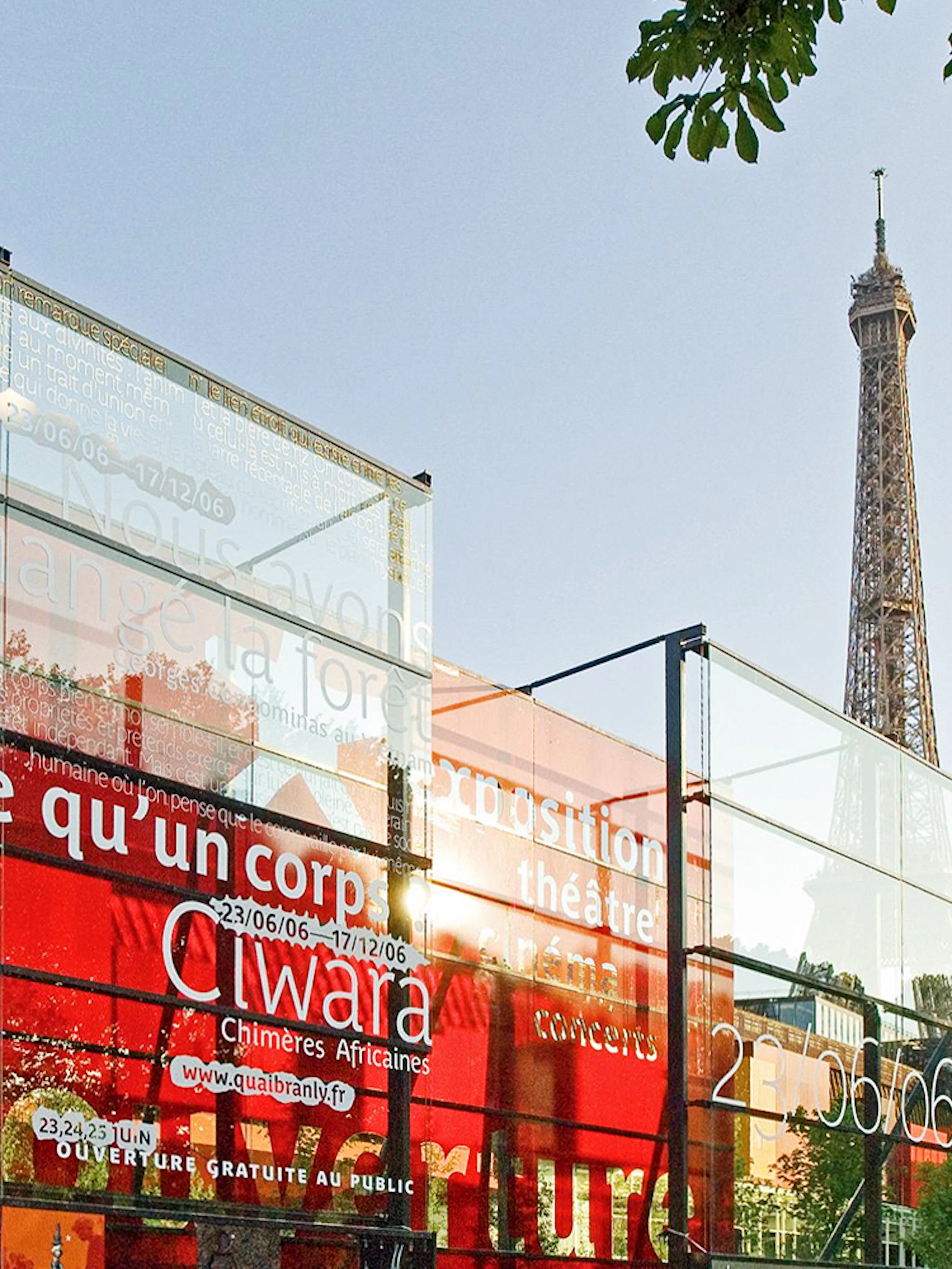 Quai Branly Museum glass facade with Eiffel Tower in background, Paris.