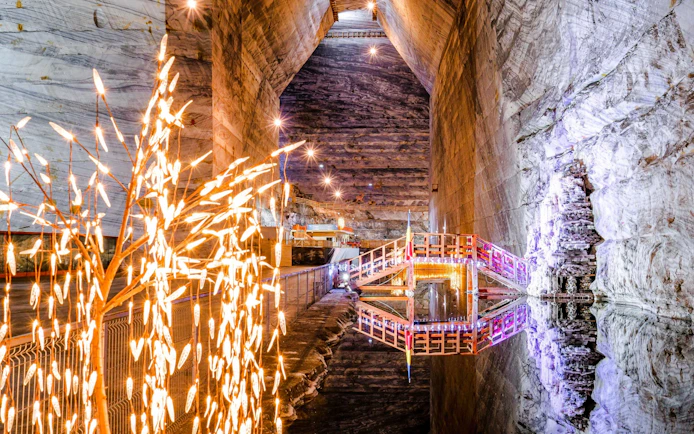 View inside Slanic Salt Mine with illuminated walkway and salt formations.