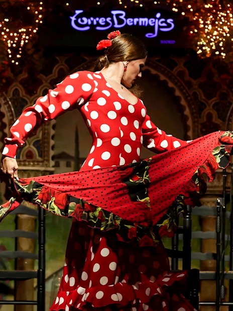 Flamenco dancer performing at Torres Bermejas in a red polka dot dress.