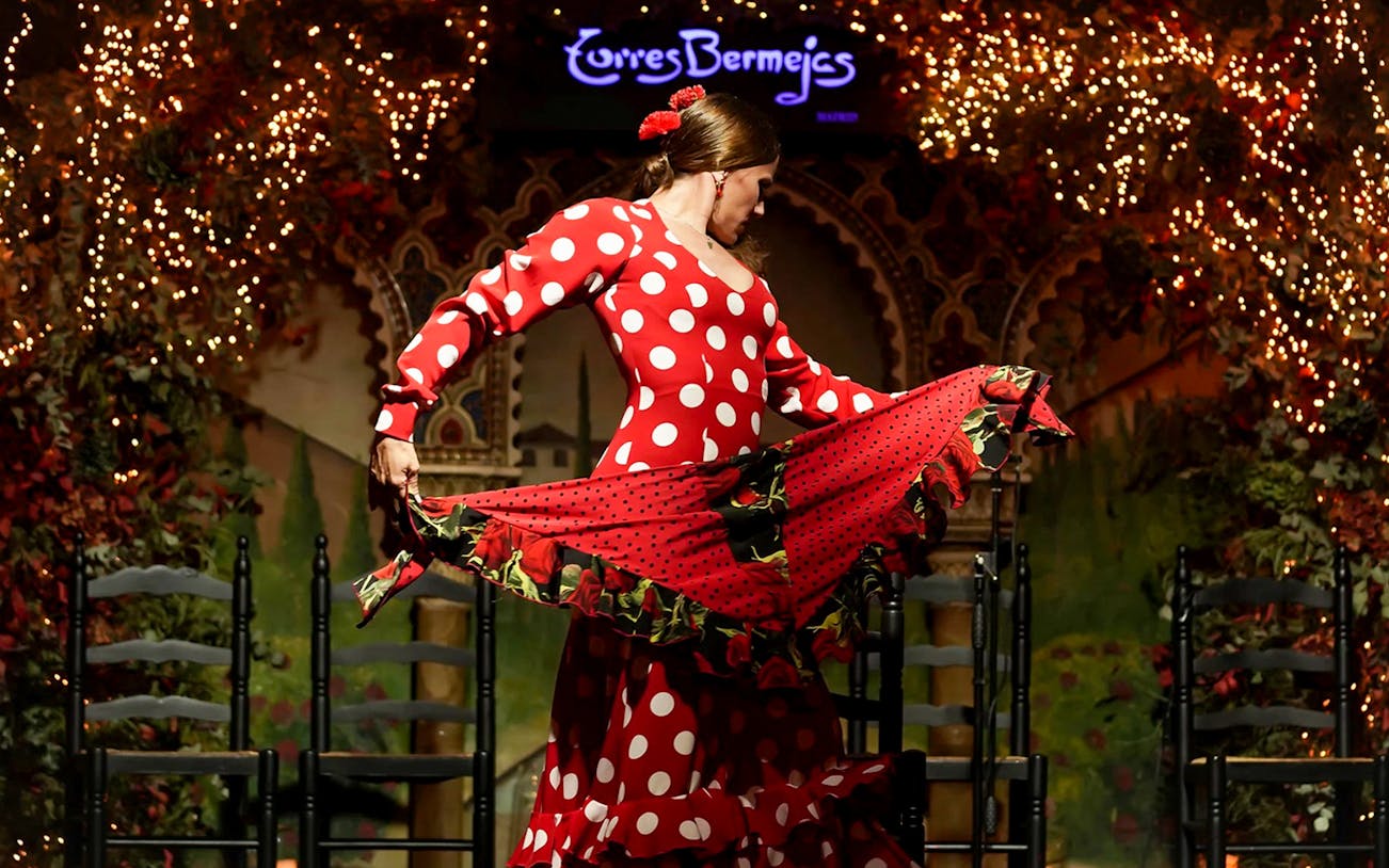 Flamenco dancer performing at Torres Bermejas in a red polka dot dress.