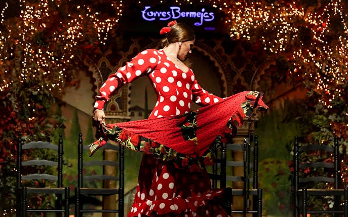 Flamenco dancer performing at Torres Bermejas in a red polka dot dress.