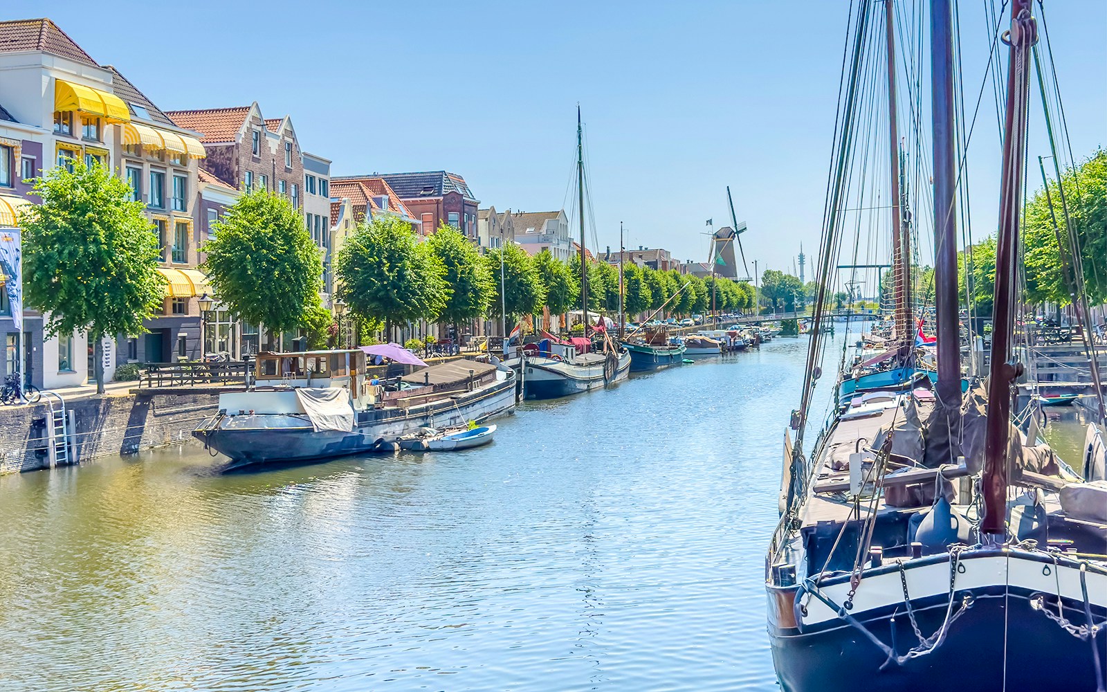 Canal with boats and historic buildings in Delfshaven, Rotterdam.