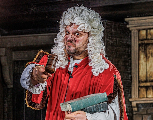 Visitors exploring the eerie corridors of the London Dungeon, featuring historical exhibits and live actors.