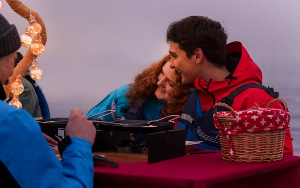 Couple enjoying raclette dinner after river rafting in Interlaken.