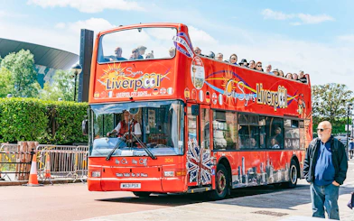 Liverpool hop on hop off bus with tourists on upper deck.