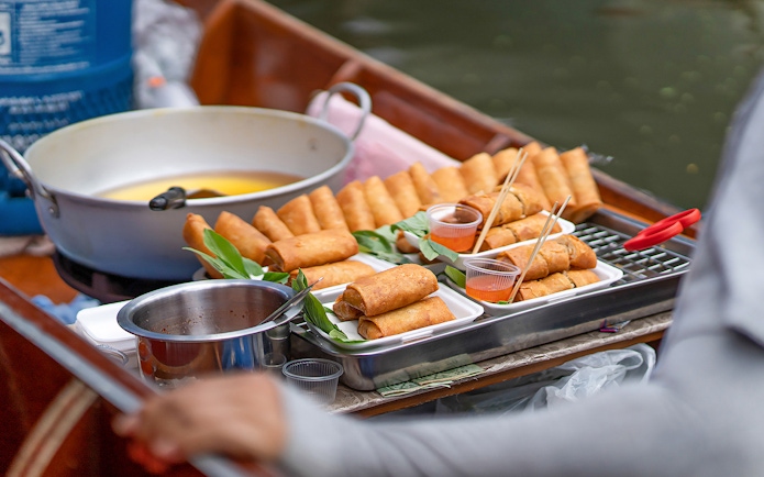 Spring rolls on a boat at Damnoen Saduak Floating Market, Bangkok tour.
