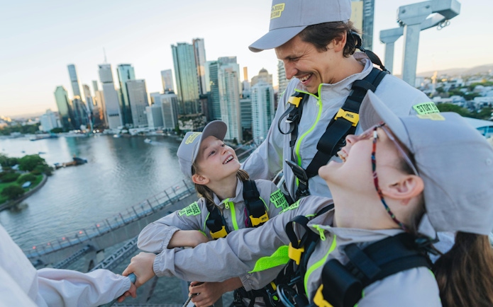 Group enjoying Story Bridge Adventure Climb with Brisbane skyline in background.