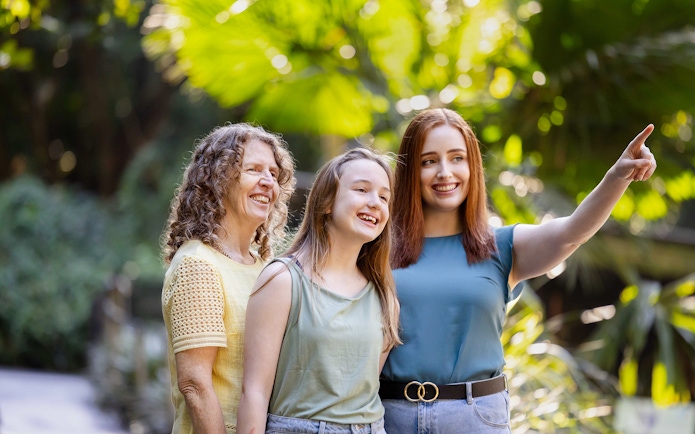 Tourists enjoying a day at Lone Pine Koala Sanctuary, surrounded by lush greenery.