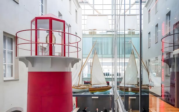 Lighthouse exhibit and sailboats inside Galata Museo del Mare, Genoa.