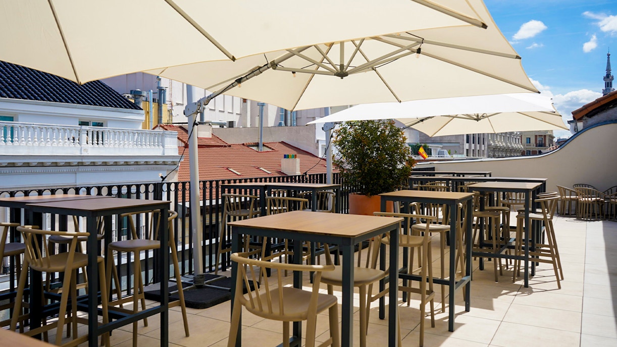 Rooftop terrace dining area with city view in Madrid's Legends Collection.
