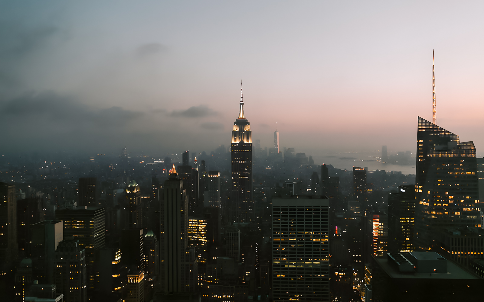 Aerial view of New York City skyline at dusk with Empire State Building.