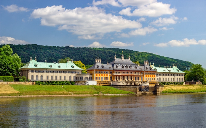 Pillnitz Castle on the Elbe River with lush greenery, Dresden, Germany.