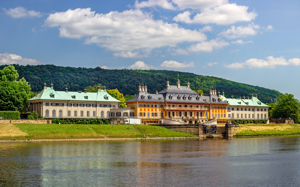 Pillnitz Castle on the Elbe River with lush greenery, Dresden, Germany.