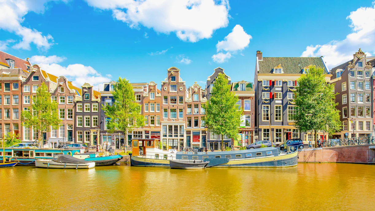 Amsterdam city skyline with colorful dancing houses along Singel canal, Netherlands.