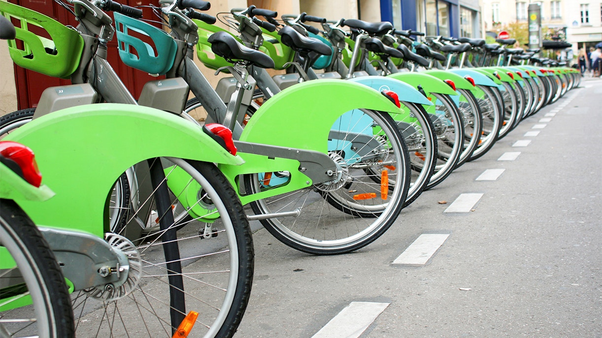 Cyclist riding a Velib bike near the Louvre Museum in Paris.