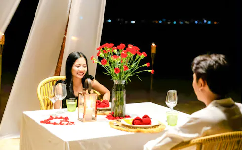 Couple dining at candlelit table on Banana Beach Koh Hey.