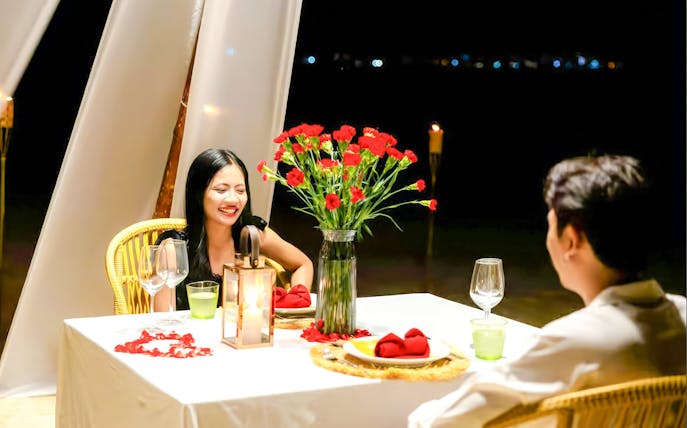 Couple dining at candlelit table on Banana Beach Koh Hey.