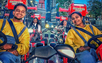 Go-karting tour participants driving through Shibuya, Tokyo with cityscape backdrop.