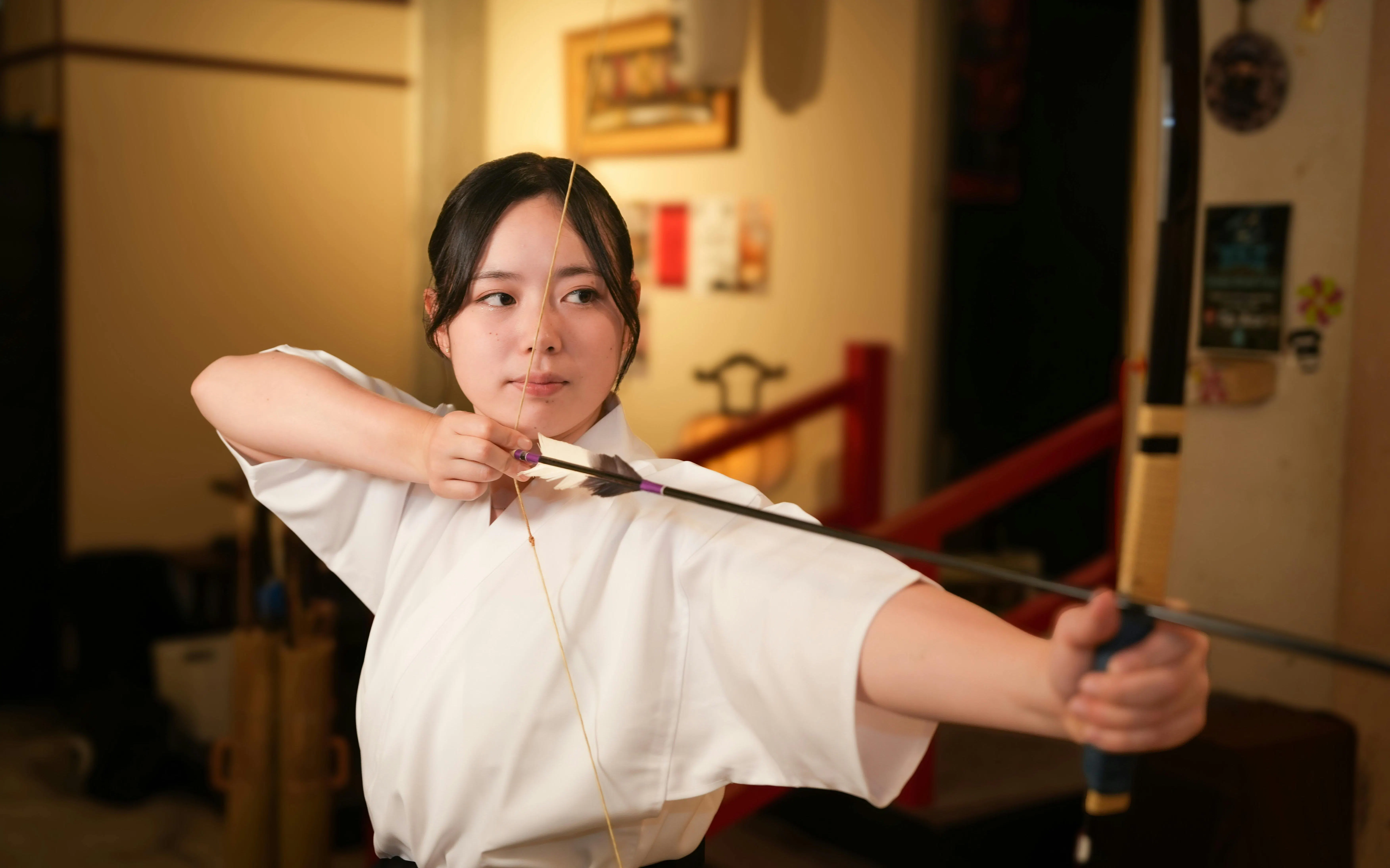 Woman practicing Kyudo archery in Tokyo dojo.