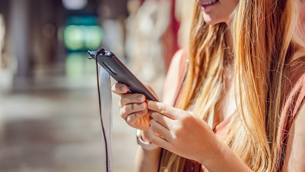Woman using audio guide on phone in a museum.