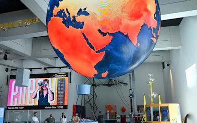 Giant globe display at Swiss Museum of Transport in Lucerne with visitors observing.