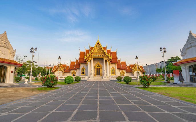 Marble Temple in Bangkok with ornate golden roof and courtyard.
