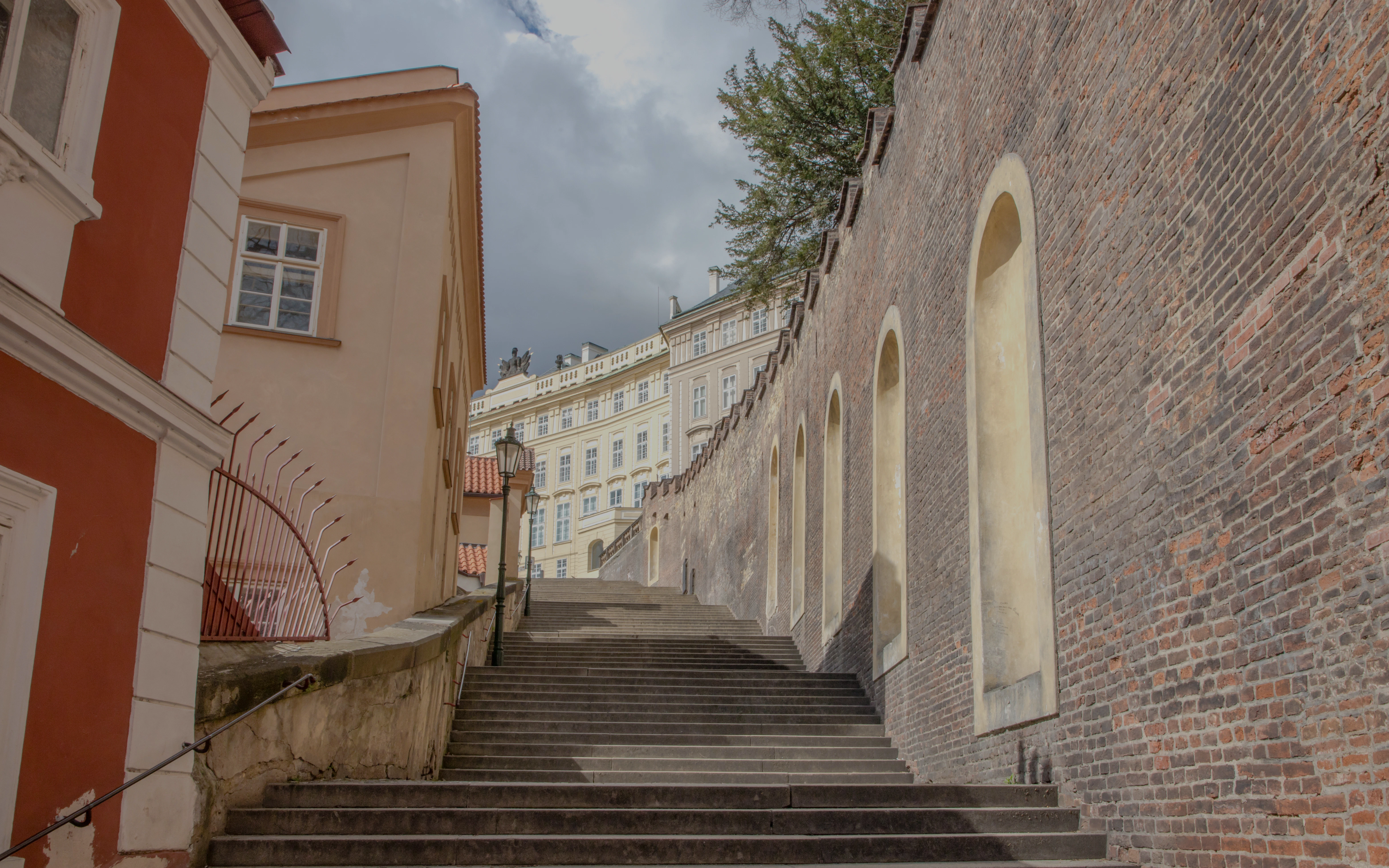 Stone steps leading to Prague Castle, surrounded by historic architecture.