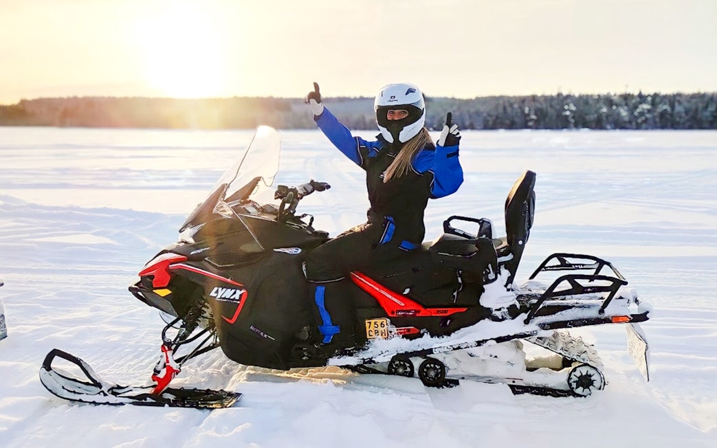 Snowmobiler giving thumbs up on Arctic safari in Rovaniemi.