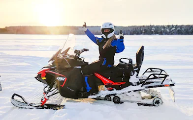 Snowmobiler giving thumbs up on Arctic safari in Rovaniemi.