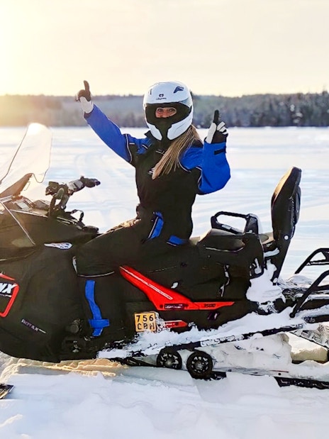 Snowmobiler giving thumbs up on Arctic safari in Rovaniemi.