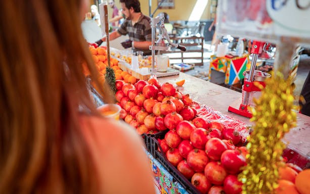 Pomegranates and oranges at a market stall during a cooking class in Palermo.