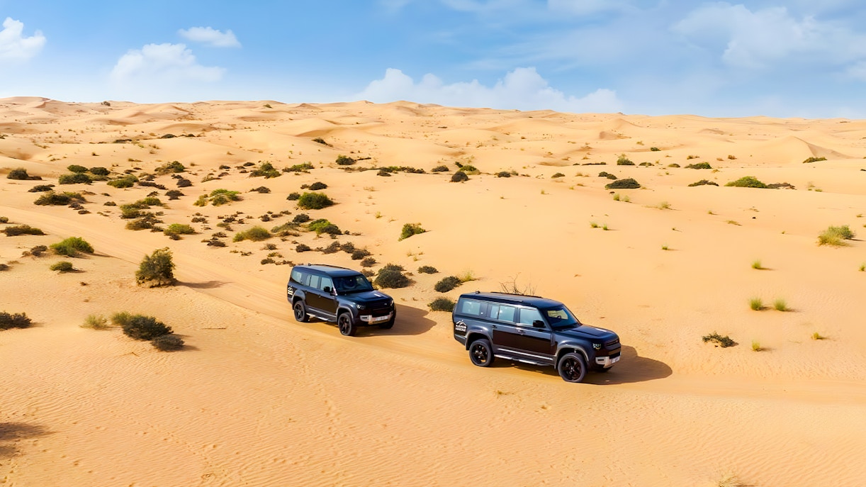 Land Rover Defenders driving through Dubai Desert Conservation Reserve.