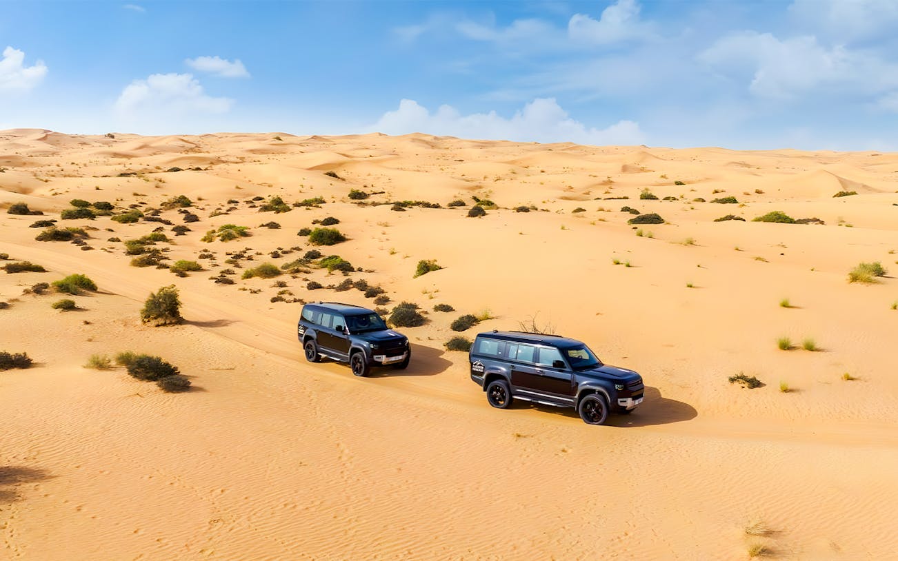 Land Rover Defenders driving through Dubai Desert Conservation Reserve.