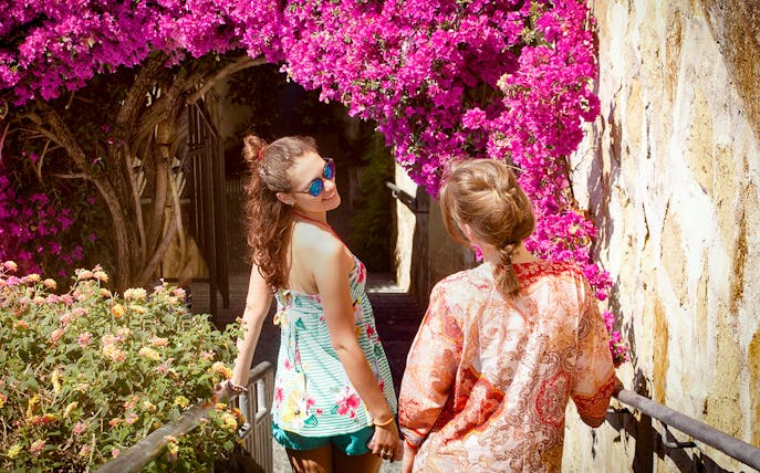 Tourists walking under vibrant bougainvillea in the Italian Riviera, Monte Carlo tour.