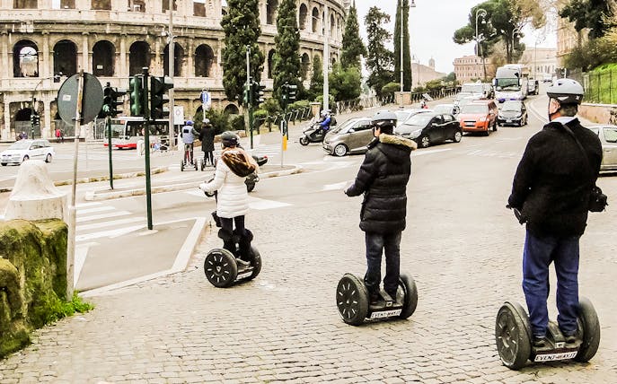 Tourists on Segways near the Colosseum in Rome during a private guided Baroque tour.