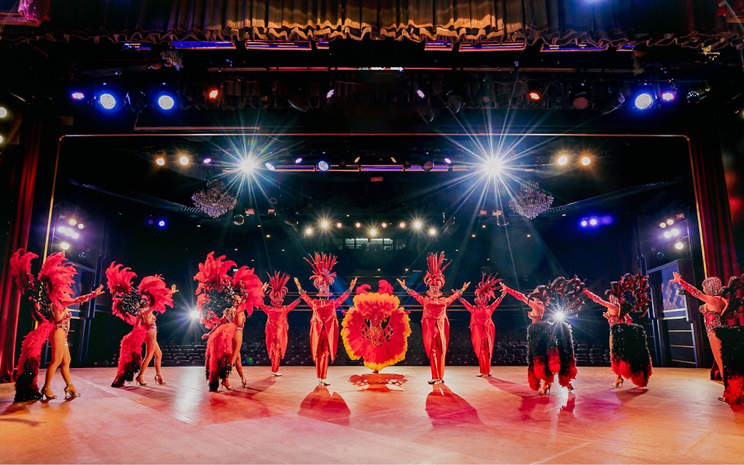 Performers in vibrant costumes on stage at Simon Cabaret Show, Phuket.