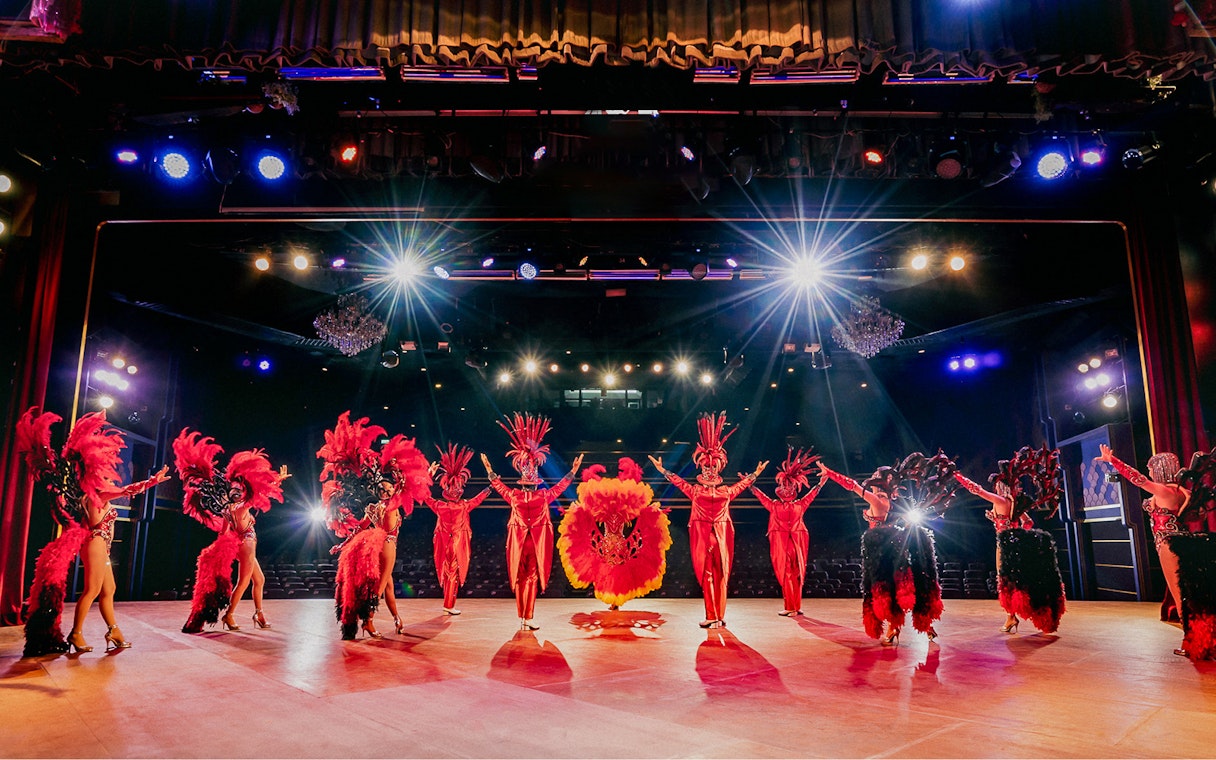 Performers in vibrant costumes on stage at Simon Cabaret Show, Phuket.