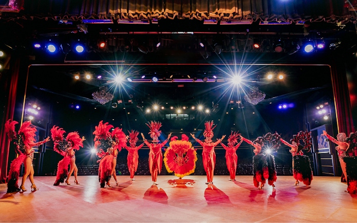 Performers in vibrant costumes on stage at Simon Cabaret Show, Phuket.