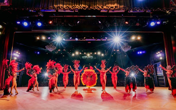 Performers in vibrant costumes on stage at Simon Cabaret Show, Phuket.