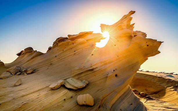 Rock formations at Al Wathba, Abu Dhabi, with sunlight peeking through.