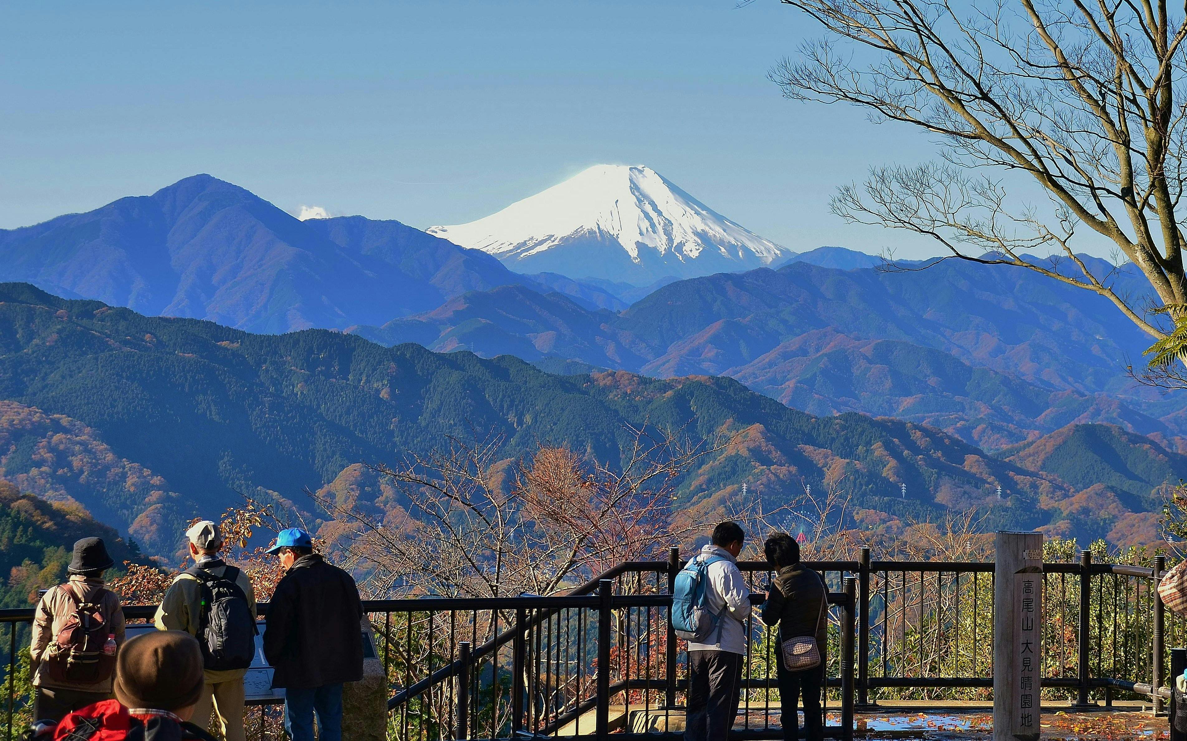 Hikers enjoying the view of Mount Fuji from Mount Takao near Tokyo.